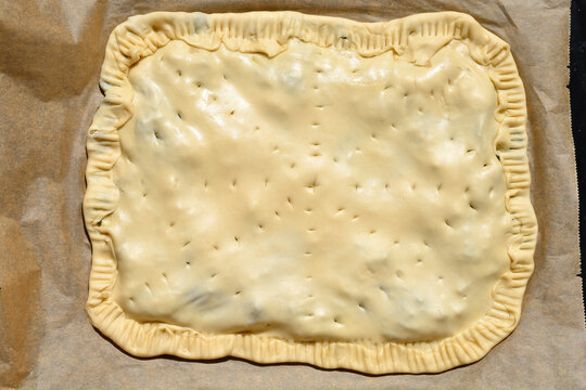 Unbaked soparnik on a baking tray - traditional Croatian chard and onion pie