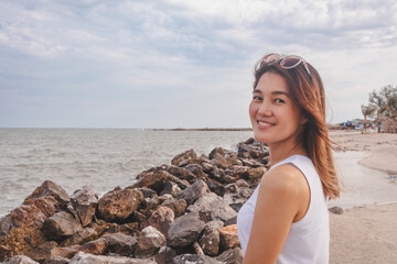 Aesthetic style of asian woman portrait relaxed on the windy beach.