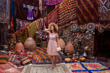 a beautiful girl in dress in a traditional turkish interior with many carpets on the wall