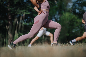 Group of individuals exercising and stretching in the park as part of their outdoor workout and calisthenics routine.