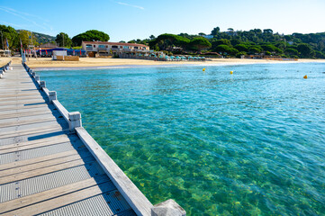 Morning view on crystal clear blue water of Plage du Debarquement white sandy beach near Cavalaire-sur-Mer and La Croix-Valmer, summer vacation on French Riviera, Var, France
