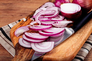 sliced red onion, on a chopping board, with a knife,Spanish onion, raw onion, close-up, top view,