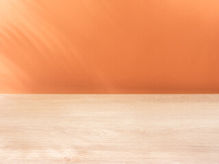 Blurred shadow of tropical palm leaves on the peach wall and table top in the foreground. Summer concept.
