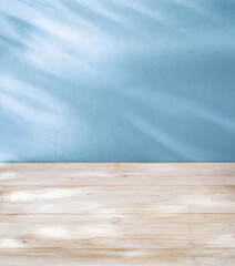 Blurred shadow of  leaves on the blue wall and table top in the foreground. Summer concept.