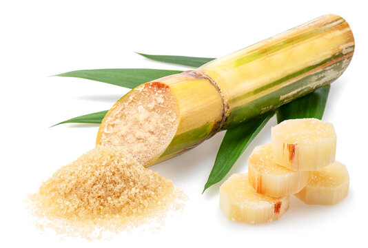 Sugarcane stalk with leaves and pile of cane sugar isolated on white background.