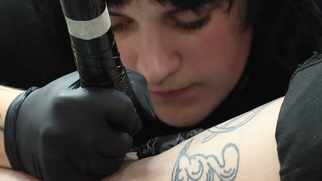 Primer plano de mujer tatuadora trabajando en el sal&oacute;n de tatuaje