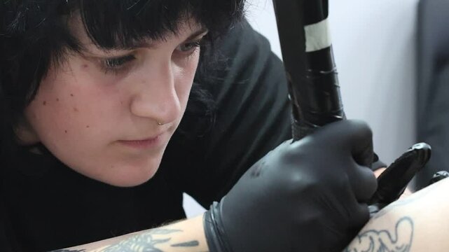 Primer plano de mujer tatuadora trabajando en el sal&oacute;n de tatuaje