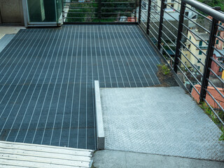 Metal ramp for wheelchair access to a public lift.