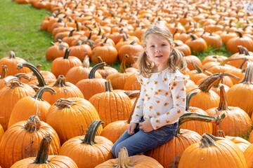 Happy girl poses for pictures at a pumpkin patch