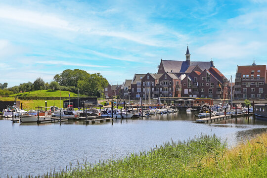 Grave, Netherlands (Noord-Brabant) - July 9. 2024: Beautiful inland harbor along cycle path at river Maas with cityscape of old dutch town