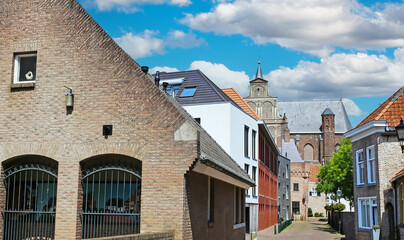 Grave, Netherlands (Noord-Brabant) - July 9. 2024: Beautiful alley with ancient buildings and old church in historical town center