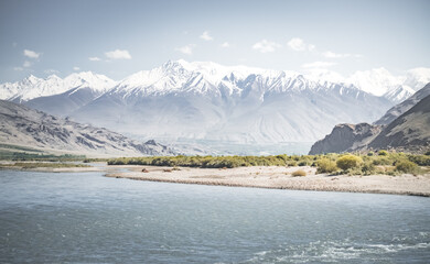 Panoramic landscape in Tien Shan mountains in Pamir with Panj river and mountains in Afghanistan and Tajikistan, sunny morning landscape for background