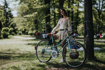 Fototapeta premium A young girl smiling while standing with a vintage bicycle in a lush park, picnic basket attached, embodying relaxation and leisure.