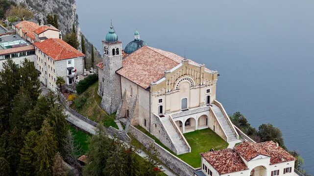Catholic church on a mountain surrounded by the Alps. Aerial view of the Eremo di Montecastello church on Lake Garda