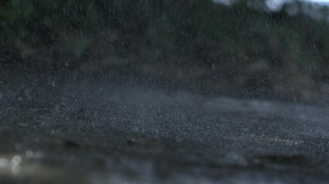 Raindrops hitting the ground in slow-motion at 1000 fps, showcasing the intricate patterns and texture of water splashes, highlighting the natural beauty and dynamics of rainfall