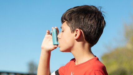 boy using an asthma inhaler practicing sports