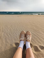 Fototapeta premium close up of feet in shoes on the beach