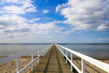 a large long pier on a sea beach