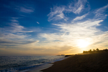 beautiful and colorful sunset, warm light and many clouds, sea waves on the sea coast