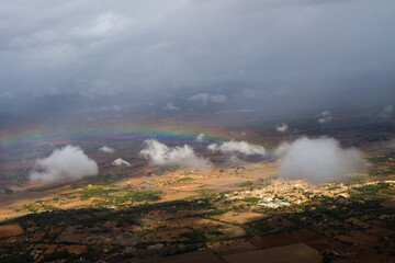 rainbow over the city in a cloudy sky from a bird's eye view