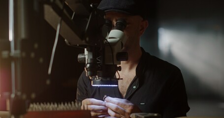 Jeweler Examining and Polishing Precious Ring Under Microscope