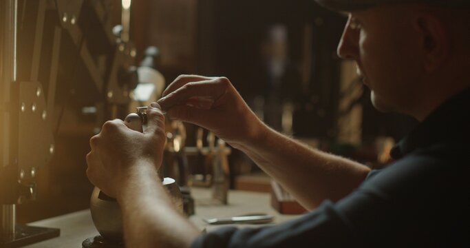 Jeweler Working on Attaching a Ring in Warmly Lit Workshop