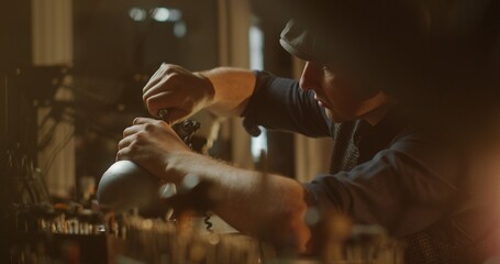 Jeweler Working on Attaching a Ring in Warmly Lit Workshop