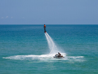 a guy flies on a flyboard at sea
