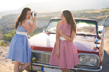 two beautiful girl in a retro dress having fun with bubbles and camera  on  mountain landscape in...