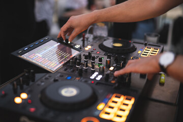 Obraz premium a DJ plays music on a controller at a party
