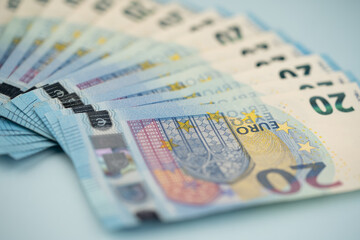 many 20 euro bills on a blue background