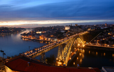 Night skyline of Porto, Portugal, with the Dom Luis I Bridge, a metal arch bridge and symbol of the city, with Douro river and Ribeira district and Porto old town in the background