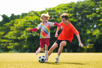 Child playing football. Kids play soccer.