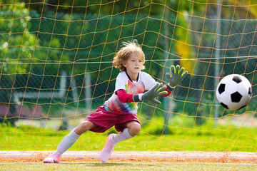 Child playing football. Kids play soccer.
