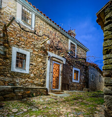 Imagen nocturna de la calle de una aldea con paredes fabricadas con piedra y adobe