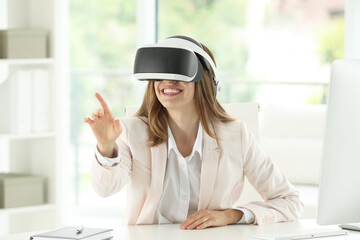 Smiling woman using virtual reality headset at workplace in office