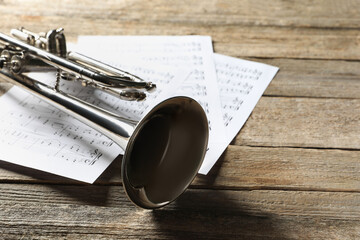 Trumpet and music sheets on wooden table, closeup © New Africa