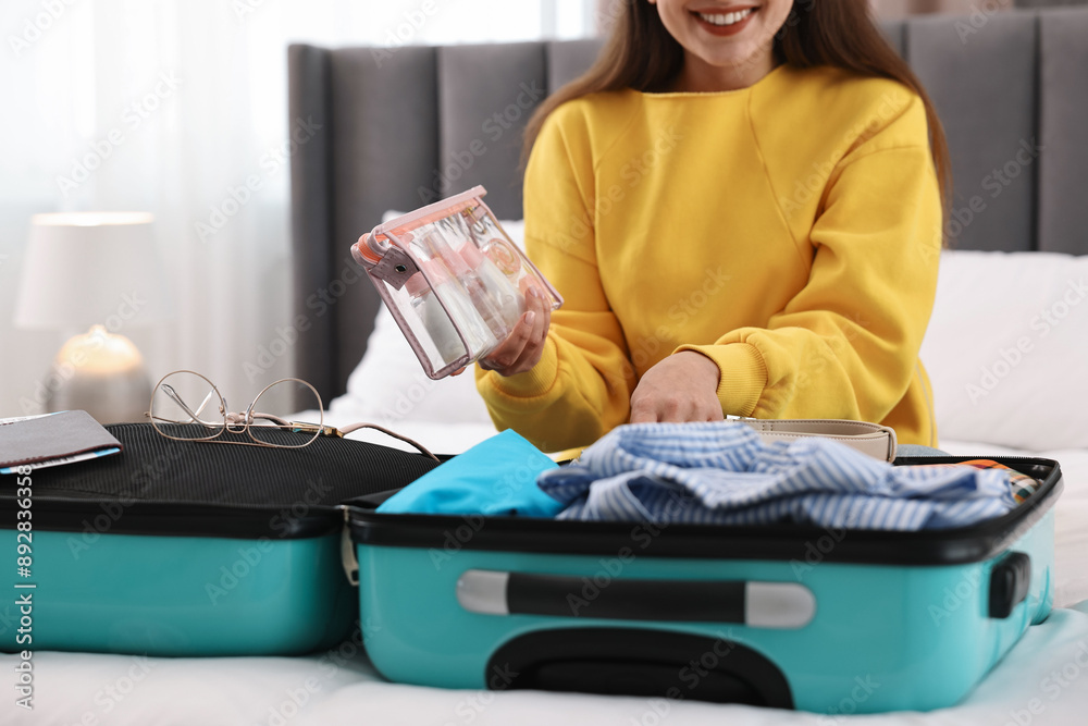 Canvas Prints Woman packing suitcase for trip on bed indoors, closeup