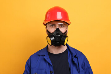 Man in respirator mask and hard hat on yellow background
