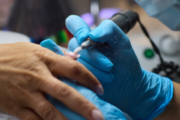 The dental specialist is using modern tools and wearing gloves to perform a precise procedure