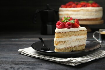 Piece of tasty sponge cake with fresh berries and mint served on black wooden table, space for text