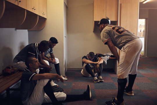 Team, baseball and together in locker room for game discussion or reflection, poor performance or sad for result. Men, sport and building with communication for training exercise or practice workout