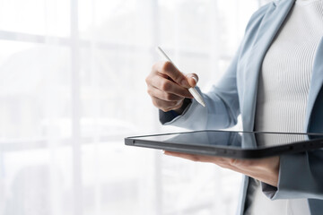 Business professional using a tablet to innovate and enhance productivity in a modern office environment.