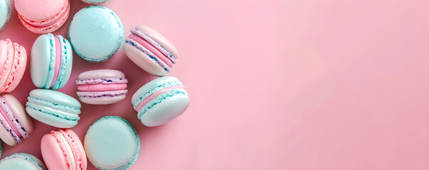 Obraz premium Close up banner of macaroons on blurred pink background with copy space. Top view pastel pink and mint macaron. French sweet meringue dessert with cream. Сoncept design for pastry, bakery, cafe