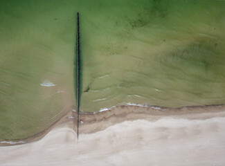 Aerial drone view of empty beach and sea side with breakwater along the Baltic Coast, Dziwnow Poland	