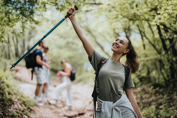 Smiling female hiker on a nature trail celebrating their outdoor adventure and teamwork on a sunny...