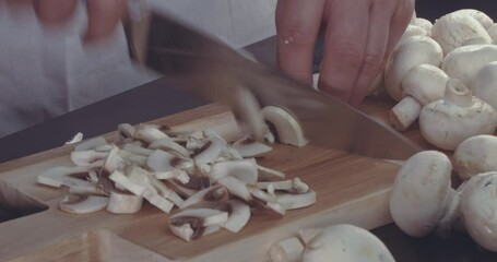 A professional chef slices the mushrooms into thin slices for a signature dish.