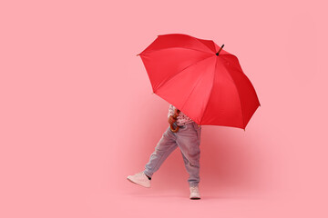 Little girl with red umbrella on pink background © New Africa