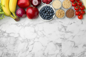 Different fresh products on white marble table, flat lay and space for text. Source of prebiotics