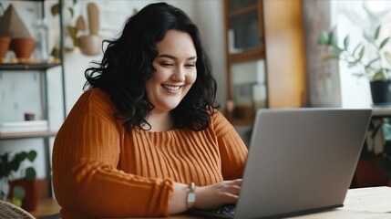 Naklejka premium A smiling woman is using her laptop.